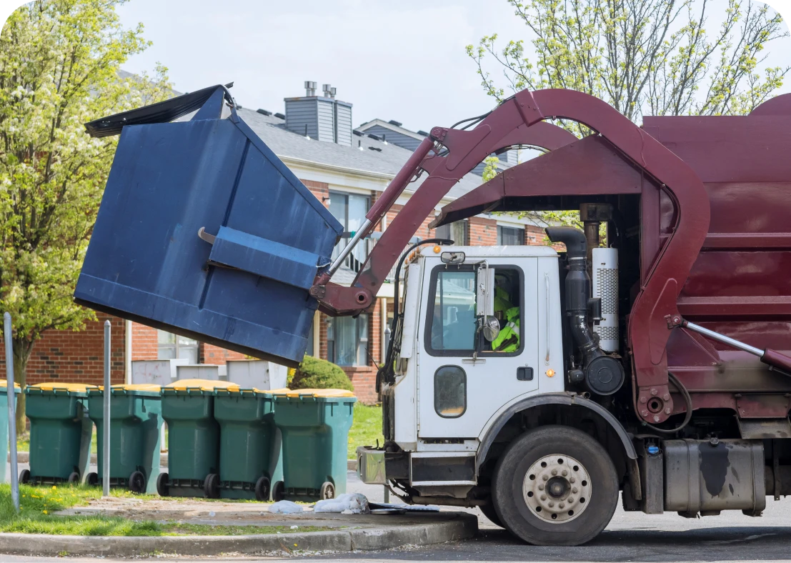 Garbage truck emptying large dumpster