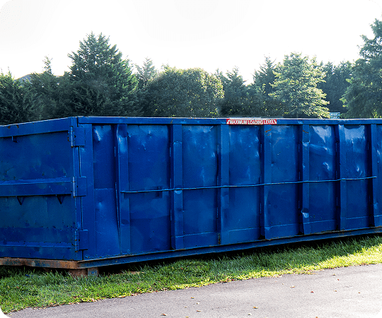 Blue industrial dumpster on grass