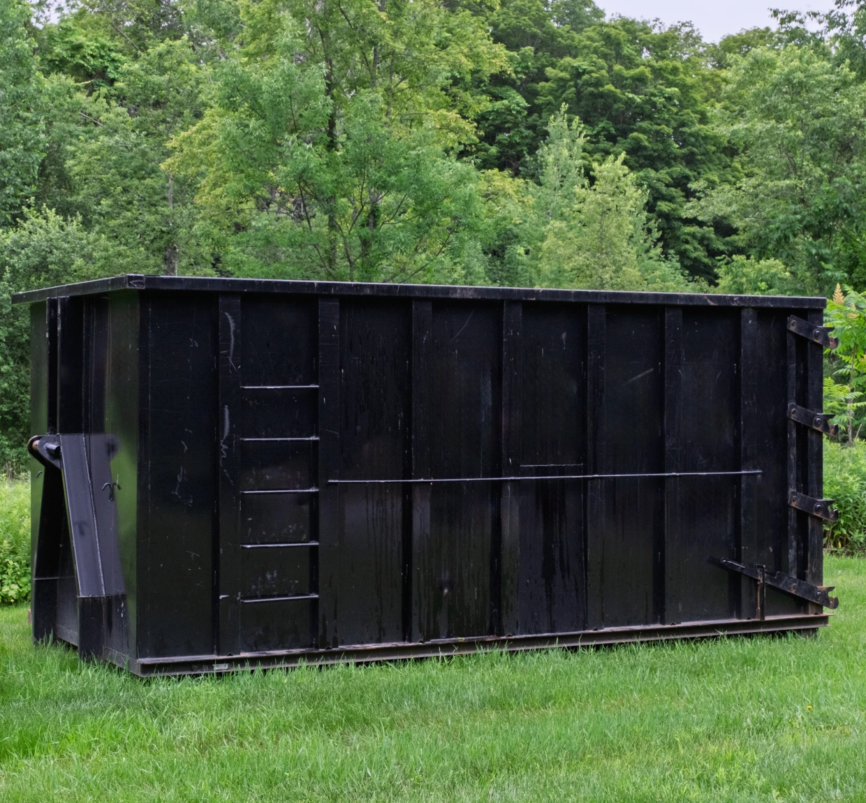 Large black container in grassy area