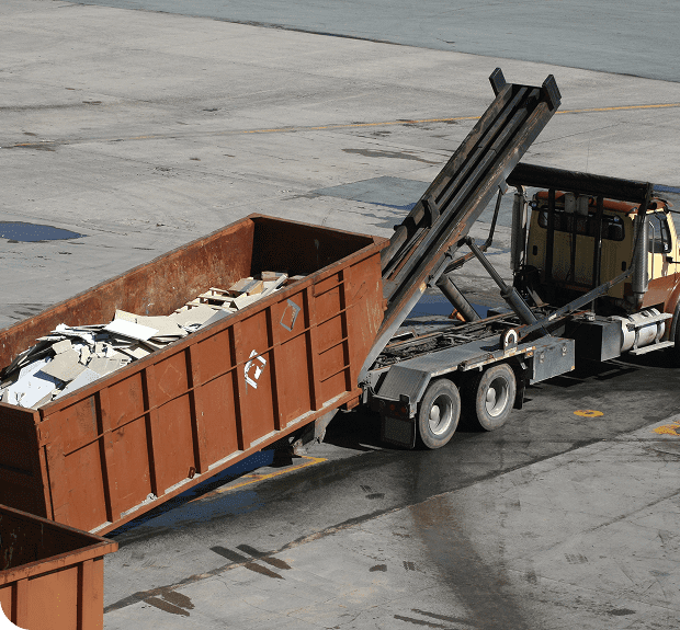 Truck unloading metal scraps into container